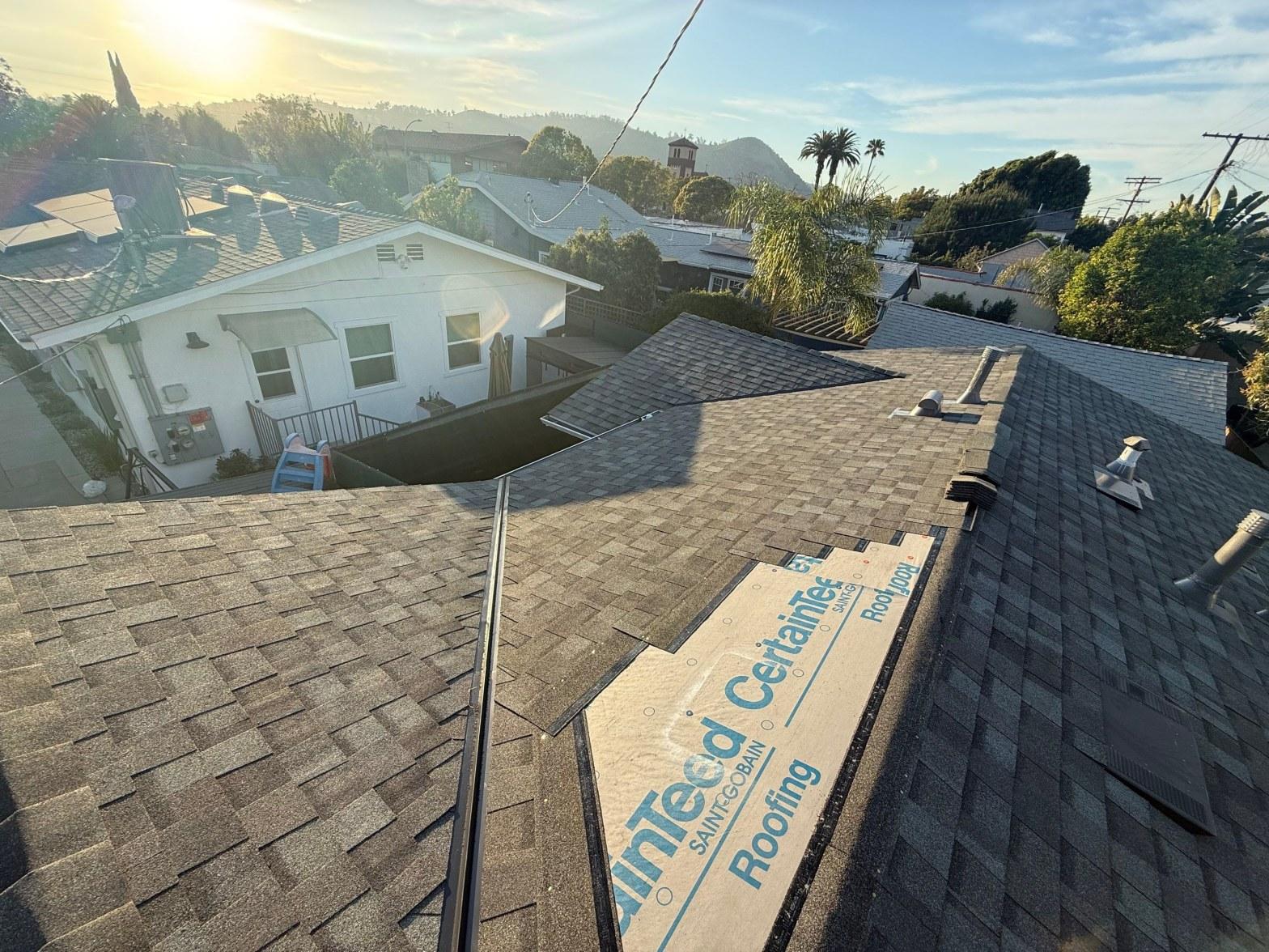 CertainTeed Saint-Gobain roofing underlayment visible on residential roof mid-installation with gray asphalt shingles surrounding it.