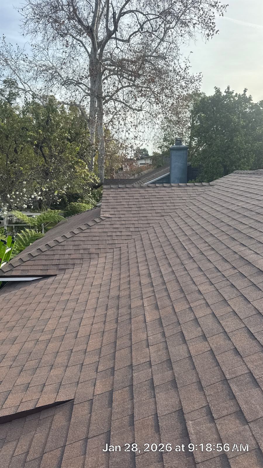 Completed asphalt shingle roof with hip ridges and metal chimney flue | Roof Replacement Inc Completed asphalt shingle roof with hip ridges and metal chimney flue — Roof Replacement Inc