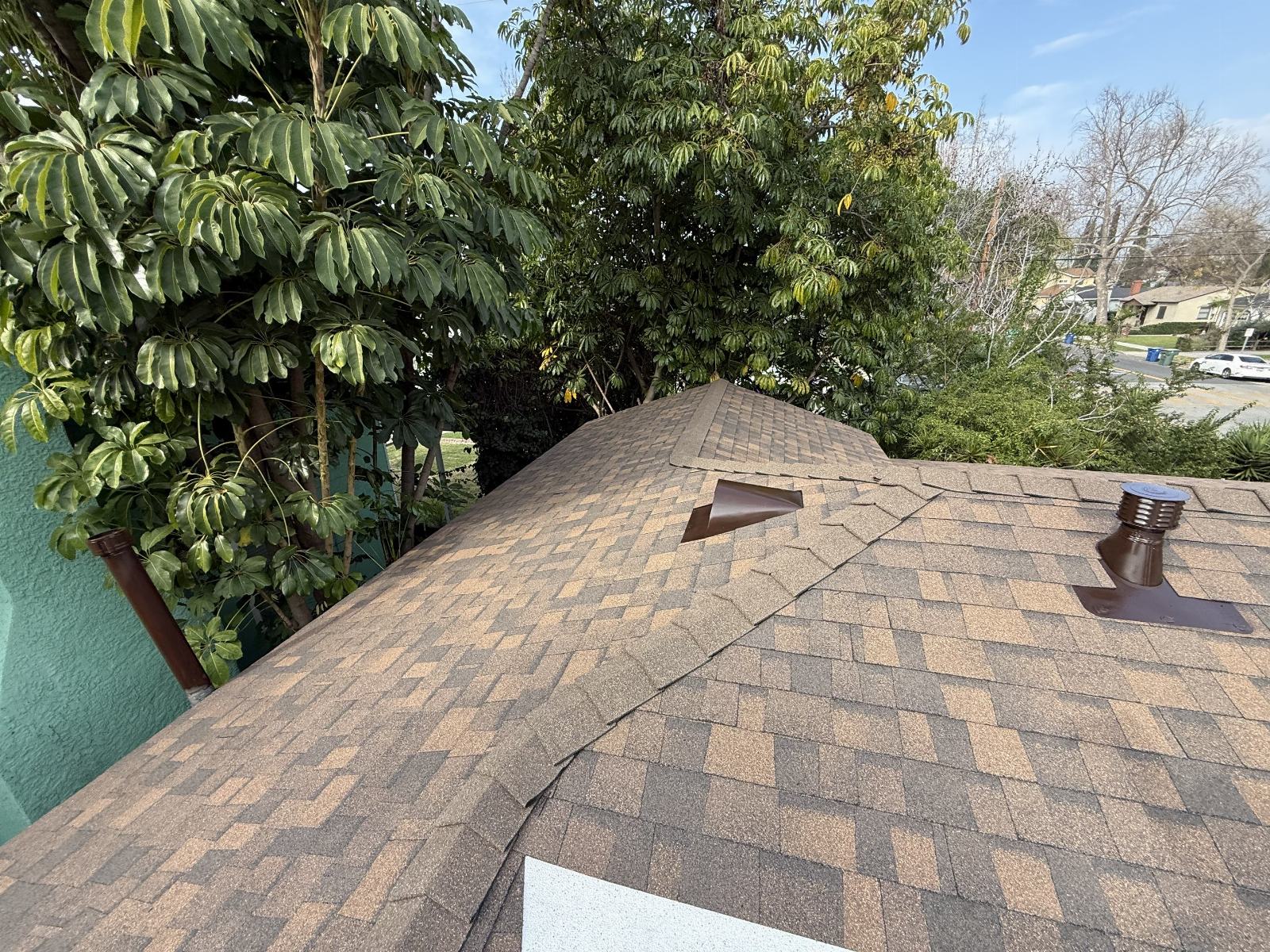 Brown asphalt shingle roof with two pipe vents and hip ridge in Burbank | Roof Replacement Inc brown asphalt shingle roof with two pipe vents and hip ridge — Burbank — Roof Replacement Inc