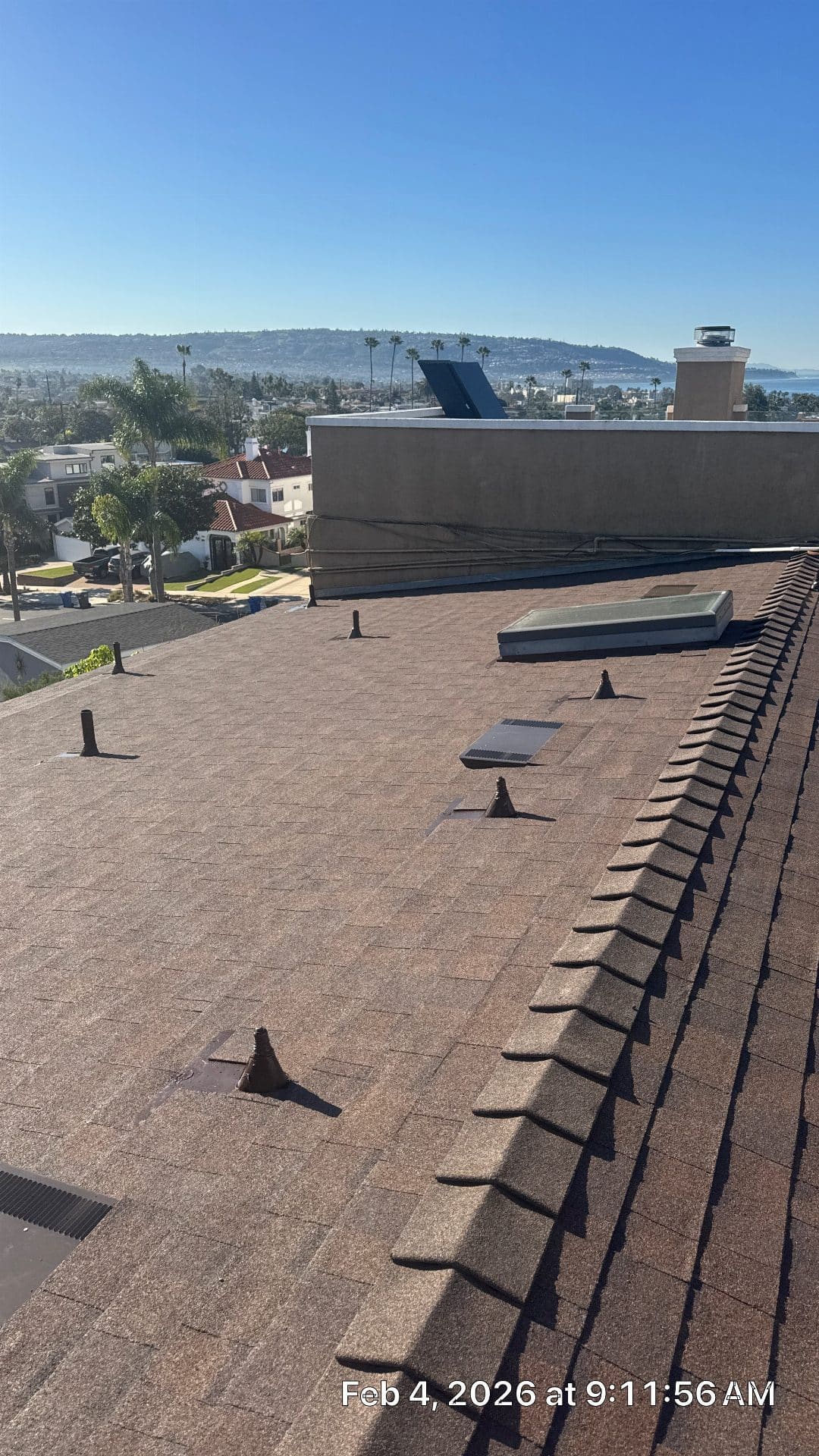 Asphalt shingle roof with pipe boots, skylight, and parapet wall — Roof Replacement Inc