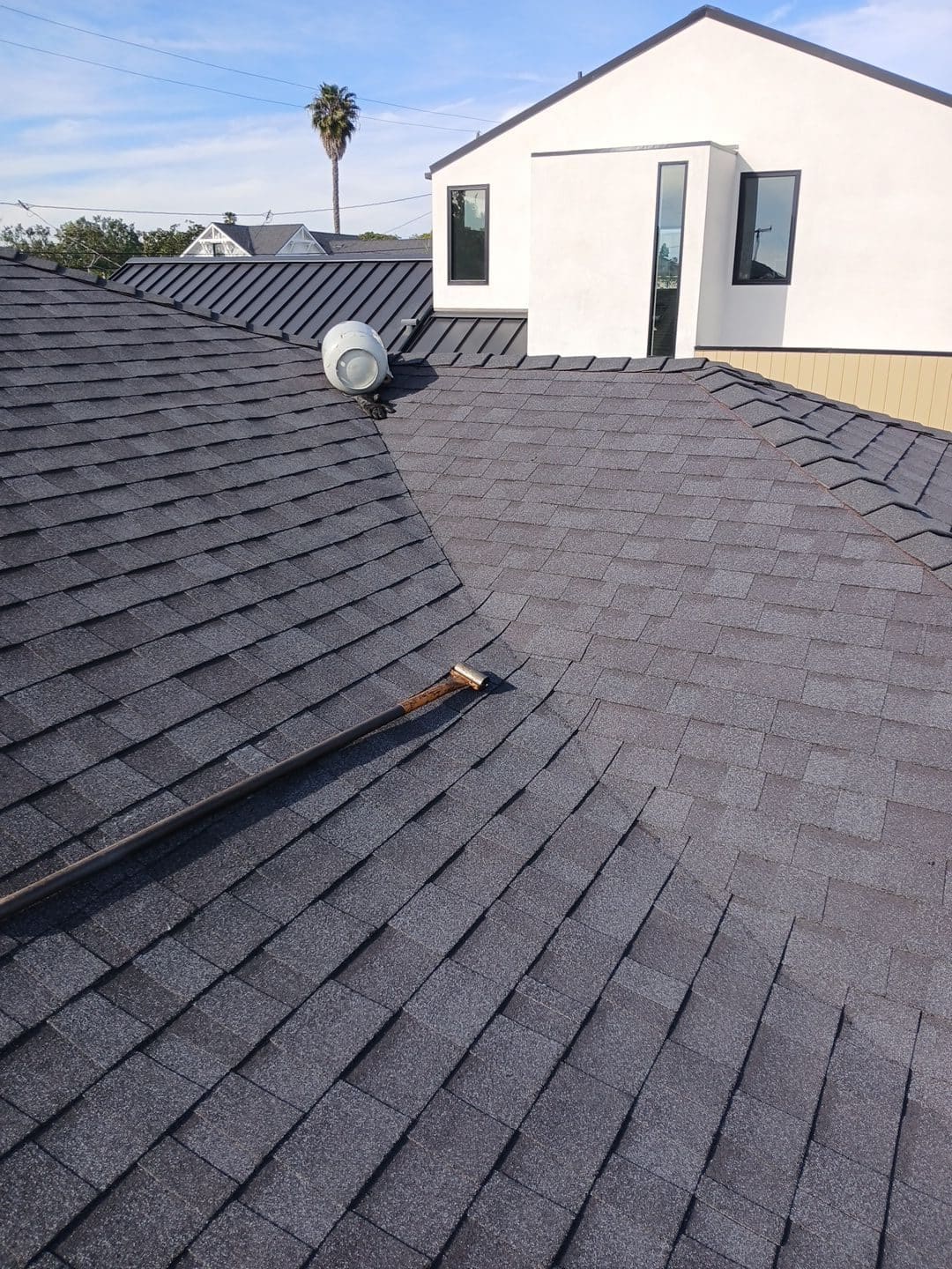 Dark asphalt shingle roof with pipe vent, metal flashing, and dormer — Roof Replacement Inc