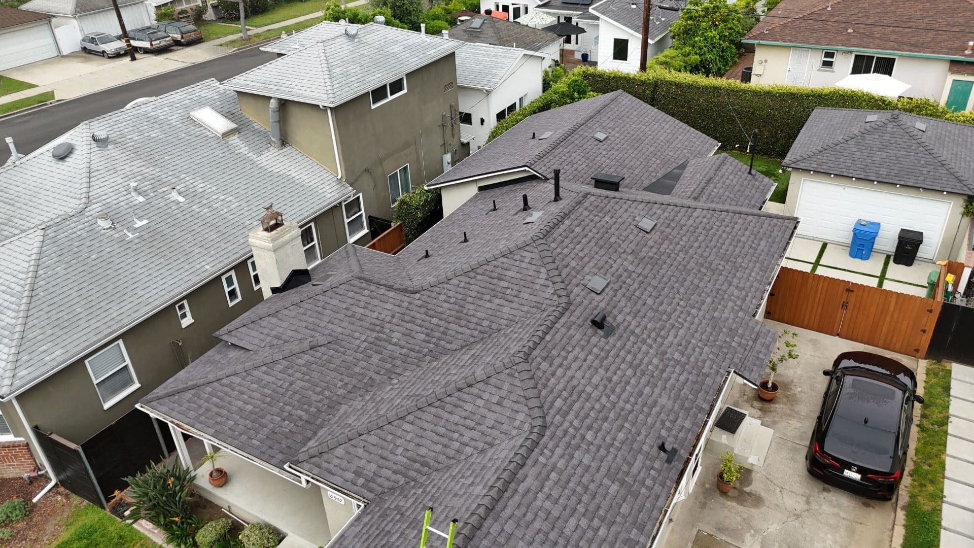 Completed dark gray asphalt shingle hip roof with multiple vents and skylights | Roof Replacement Inc Completed dark gray asphalt shingle hip roof with multiple vents and skylights — Roof Replacement Inc