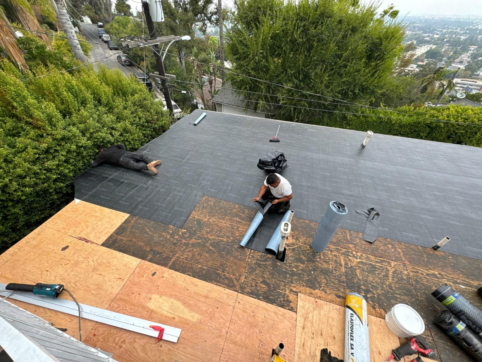 Flat TPO membrane roof on a Southern California home with drainage scuppers and HVAC equipment