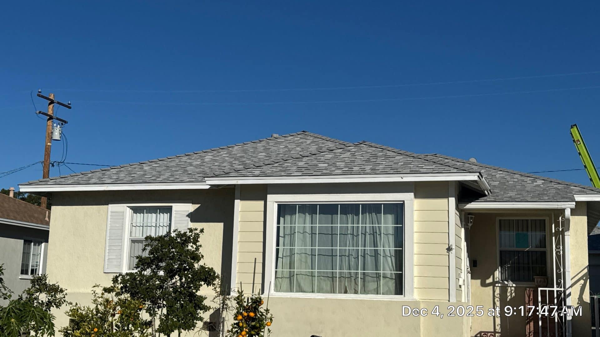 Completed hip roof with gray asphalt shingles on stucco house | Roof Replacement Inc Completed hip roof with gray asphalt shingles on stucco house — Roof Replacement Inc