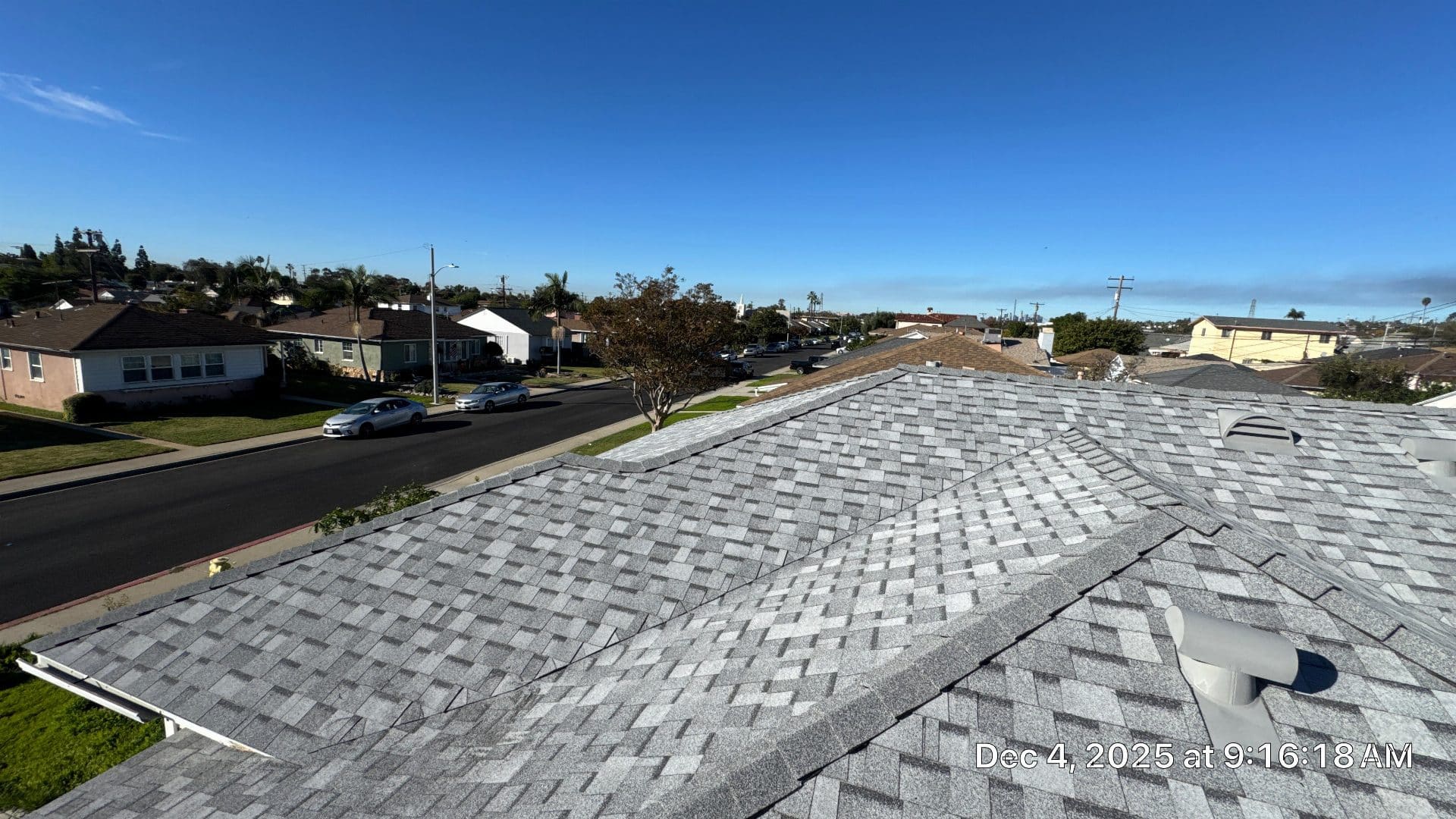 Gray asphalt shingle roof with hip ridges and exhaust vents | Roof Replacement Inc Gray asphalt shingle roof with hip ridges and exhaust vents — Roof Replacement Inc