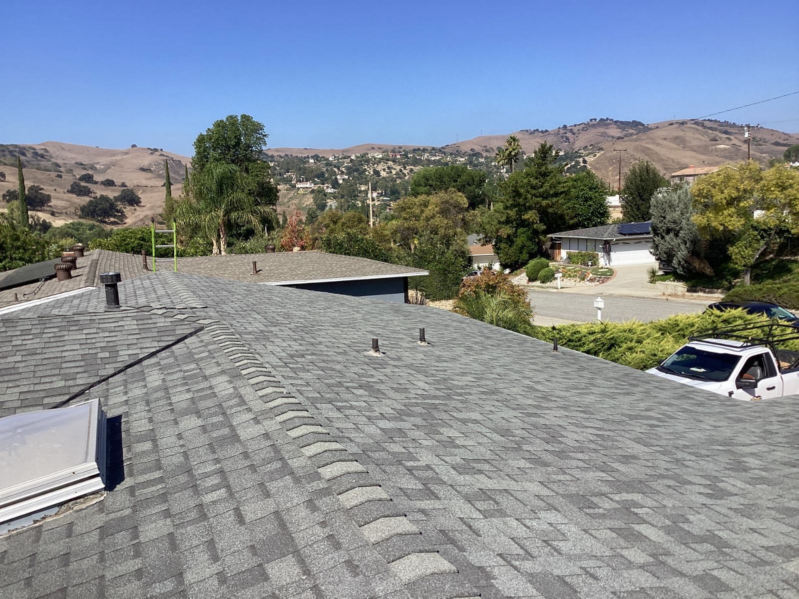 Gray asphalt shingle roof with pipe vents skylight and hills in Calabasas | Roof Replacement Inc gray asphalt shingle roof with pipe vents skylight and hills — Calabasas — Roof Replacement Inc