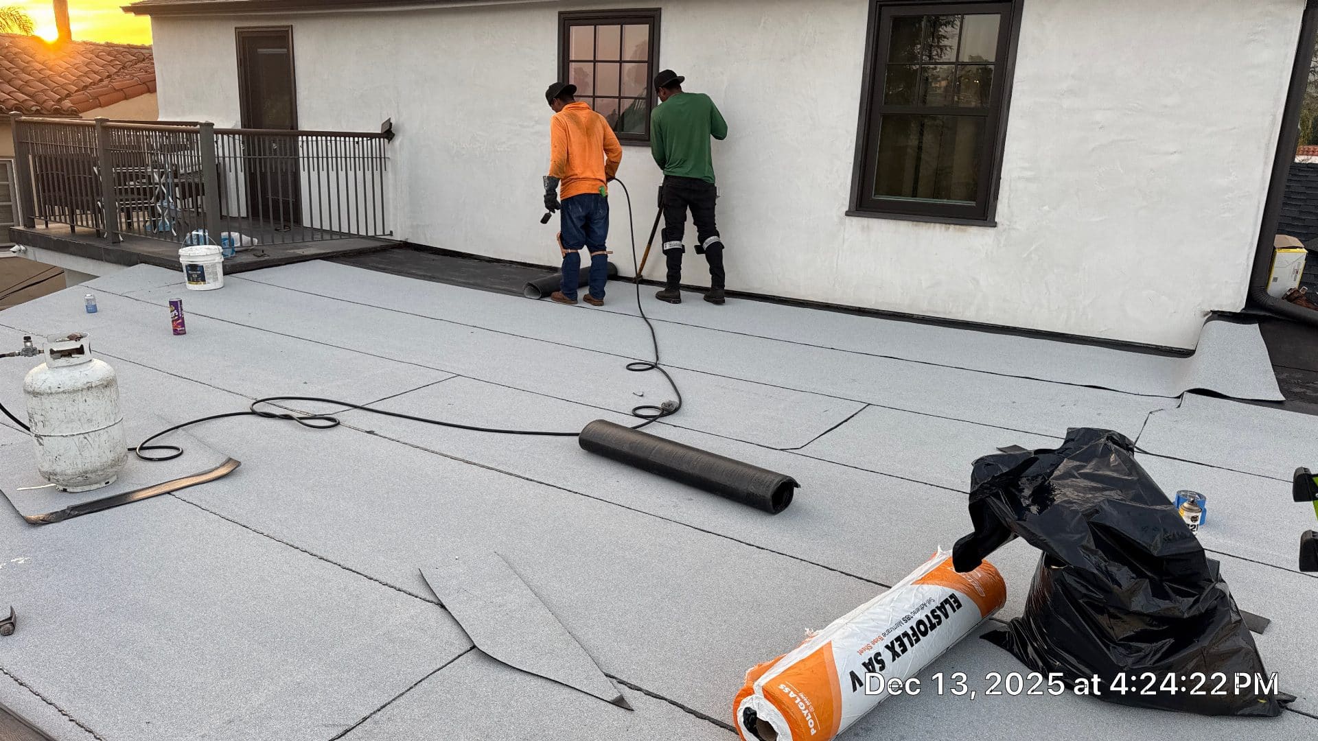 two roofers torch-applying Elastoflex SA V modified bitumen membrane flat roof — Glendale — Roof Replacement Inc