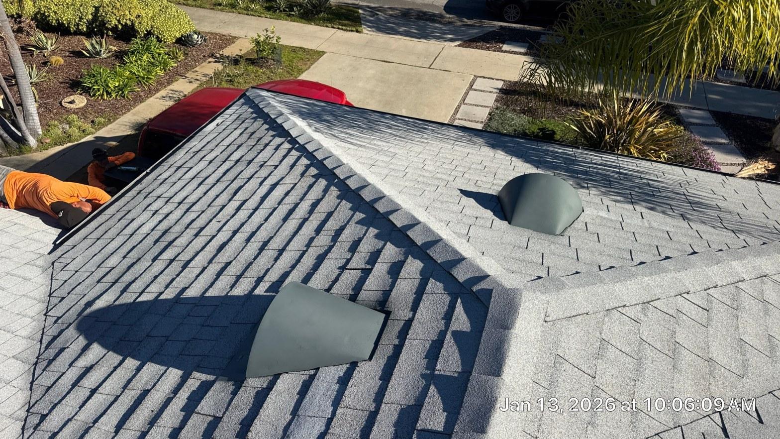 Storm-damaged residential roof with lifted shingles and exposed decking after a California storm