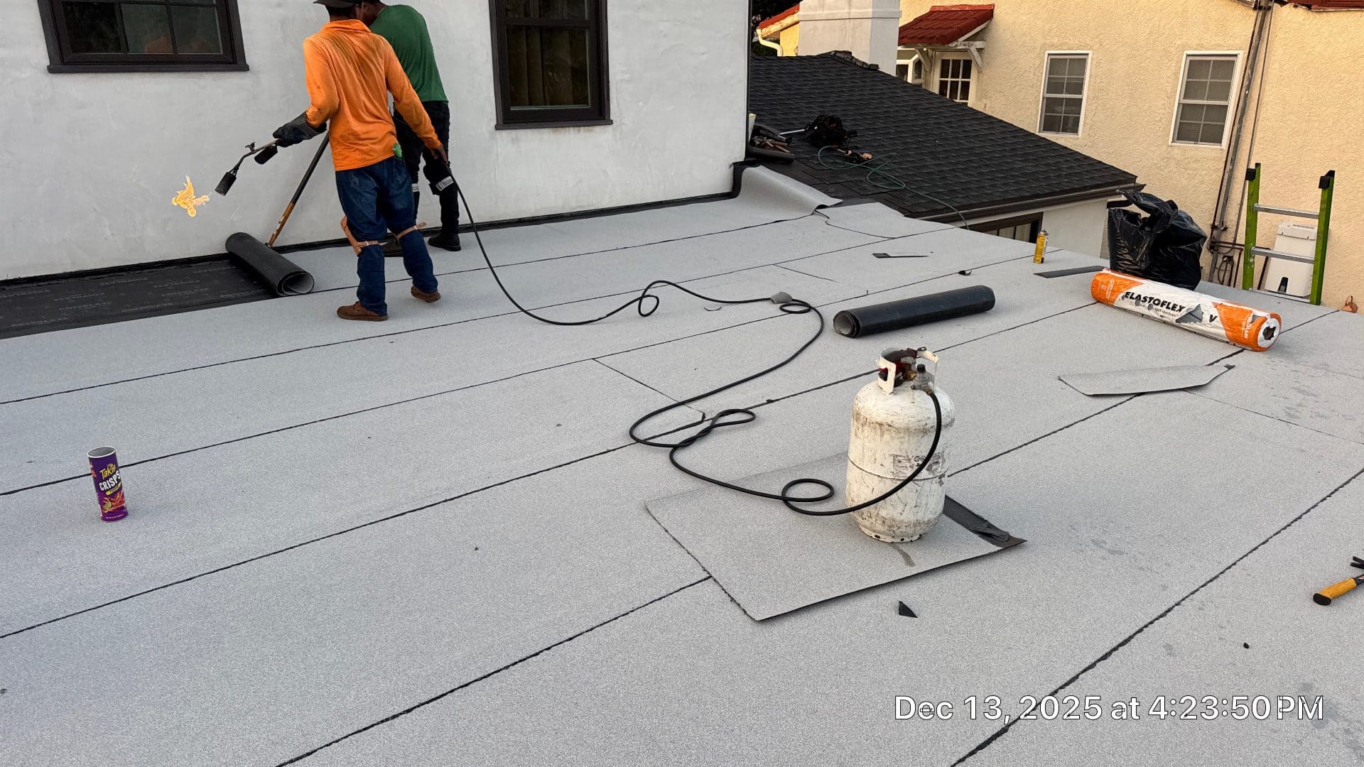 roofers torch-applying modified bitumen cap sheet on flat roof — Glendale — Roof Replacement Inc