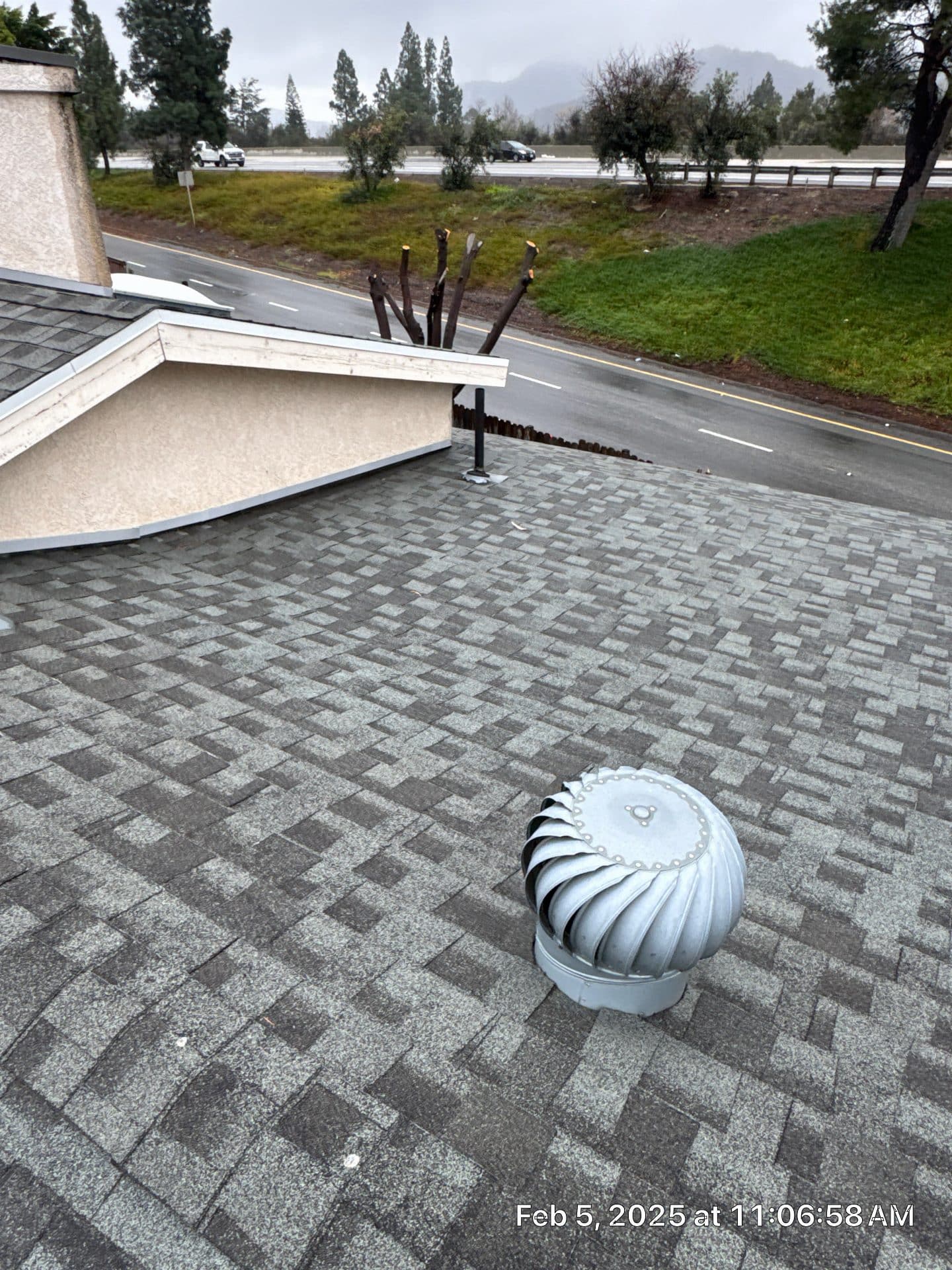 turbine vent on gray asphalt shingle roof, road visible — La Crescenta-Montrose — Roof Replacement Inc