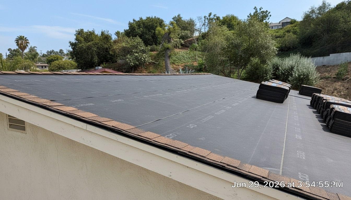 Residential roof replacement in progress showing new underlayment and staged shingles on a California home